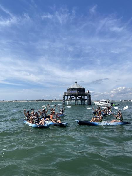 Un groupe de 5 canoës devant la réplique du phare du bout du Monde.