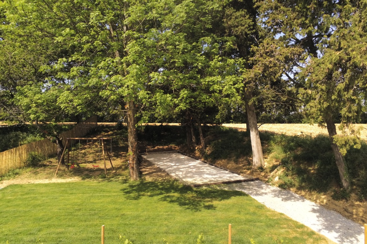 Terrain de pétanque et balançoire à l'ombre