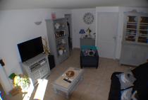 Séjour lumineux avec canapé, fauteuil, décoration d'intérieur, TV