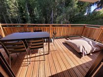 La terrasse en été avec table et chaises et gros coussin de sol