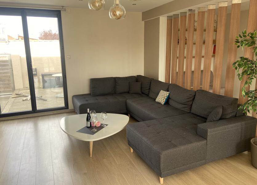 Un canapé en U, une table basse avec champagne.