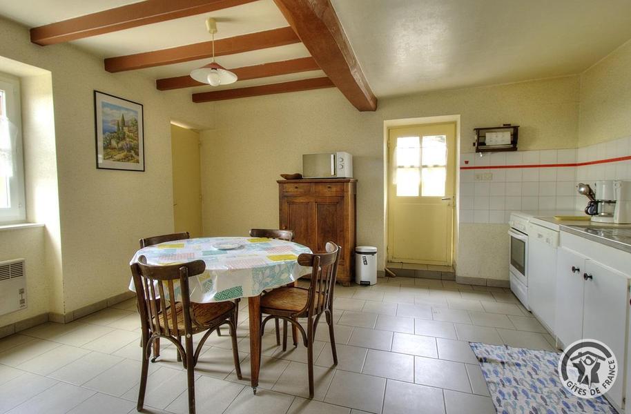 Gîte \'Les Micocouliers\' à Saint Loup, Vindry-sur-Turdine dans le Beaujolais - Rhône, proche de Tarare : la cuisine avec un accès à la terrasse et une chambre (rez-de-chaussée).
