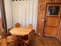 Séjour avec table à manger en bois, parquet au sol, ameublement bois, fenêtre