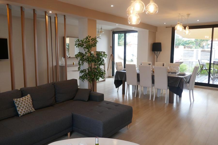 Le salon avec canapé, table dressée et 8 chaises.