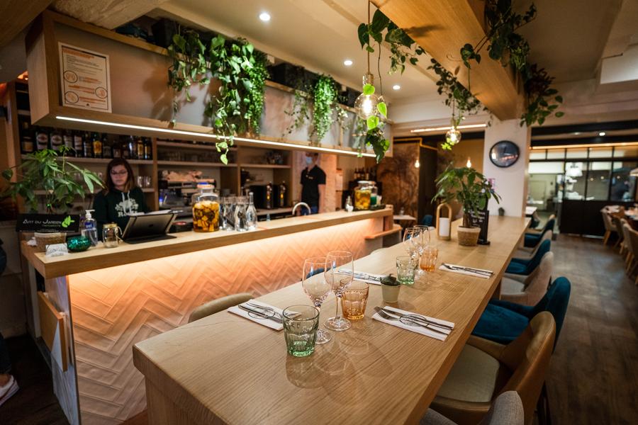 Une grande table haute tout en longueur, en fond le bar.