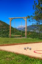 Balançoire suspendue avec vue panoramique sur la vallée et terrain de pétanque