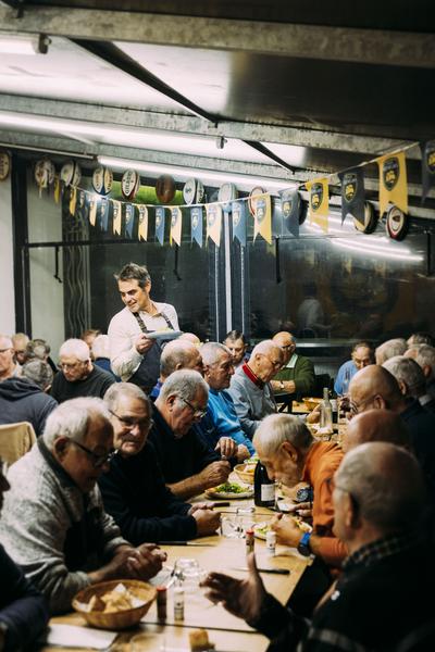 Des clients attablés sur les tables, sous le barnum