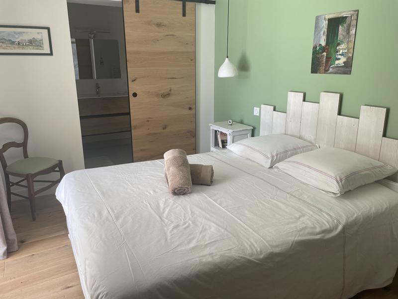 La "chambre olive", son lit double et son accès à la salle d'eau privée.