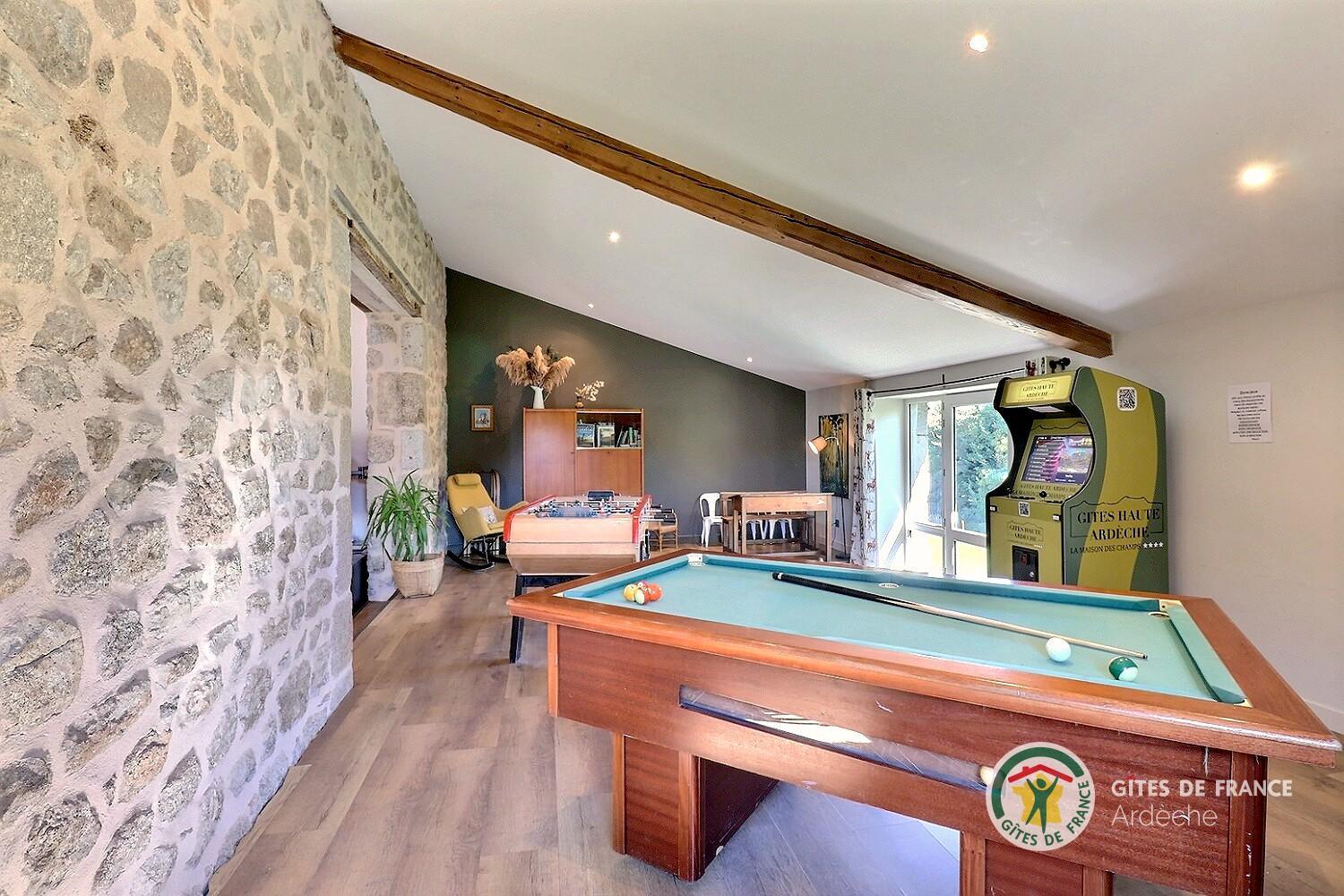 Salle de jeux dans la pièce de vie (billard, babyfoot, arcade de jeux, flipper, fléchettes, ...)
