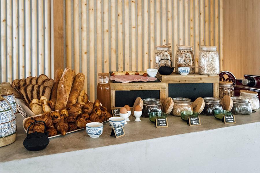 Le buffet du petit-déjeuner avec des cérales, des viennoiseries, du pain, des oeufs, de la charcuterie, du fromage.