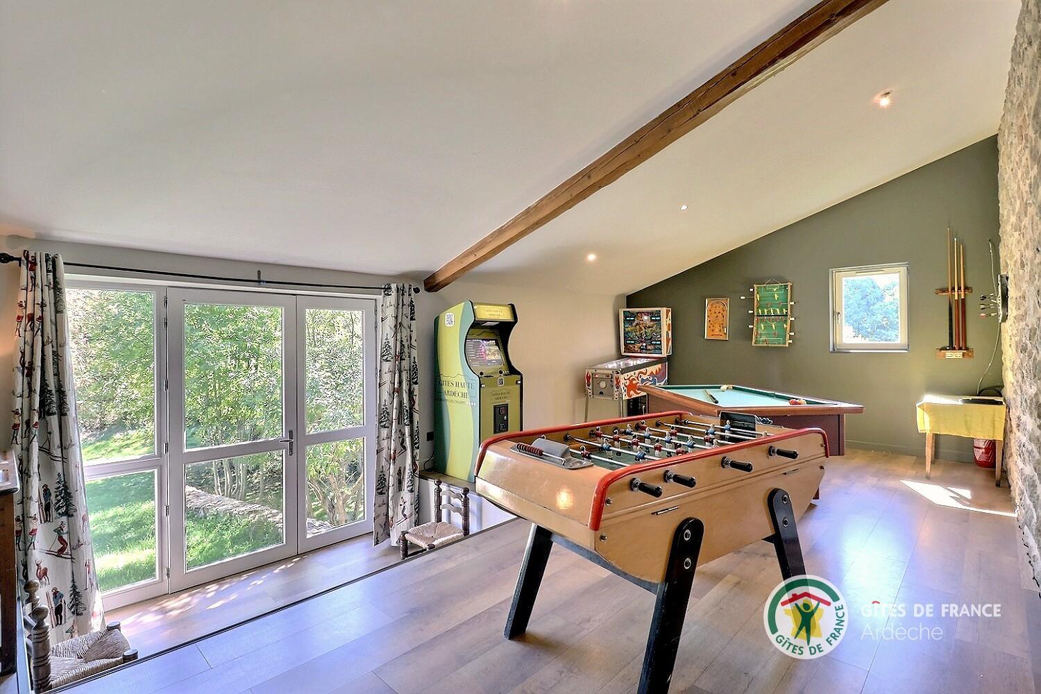 Salle de jeux dans la pièce de vie (billard, babyfoot, arcade de jeux, flipper, fléchettes, ...)