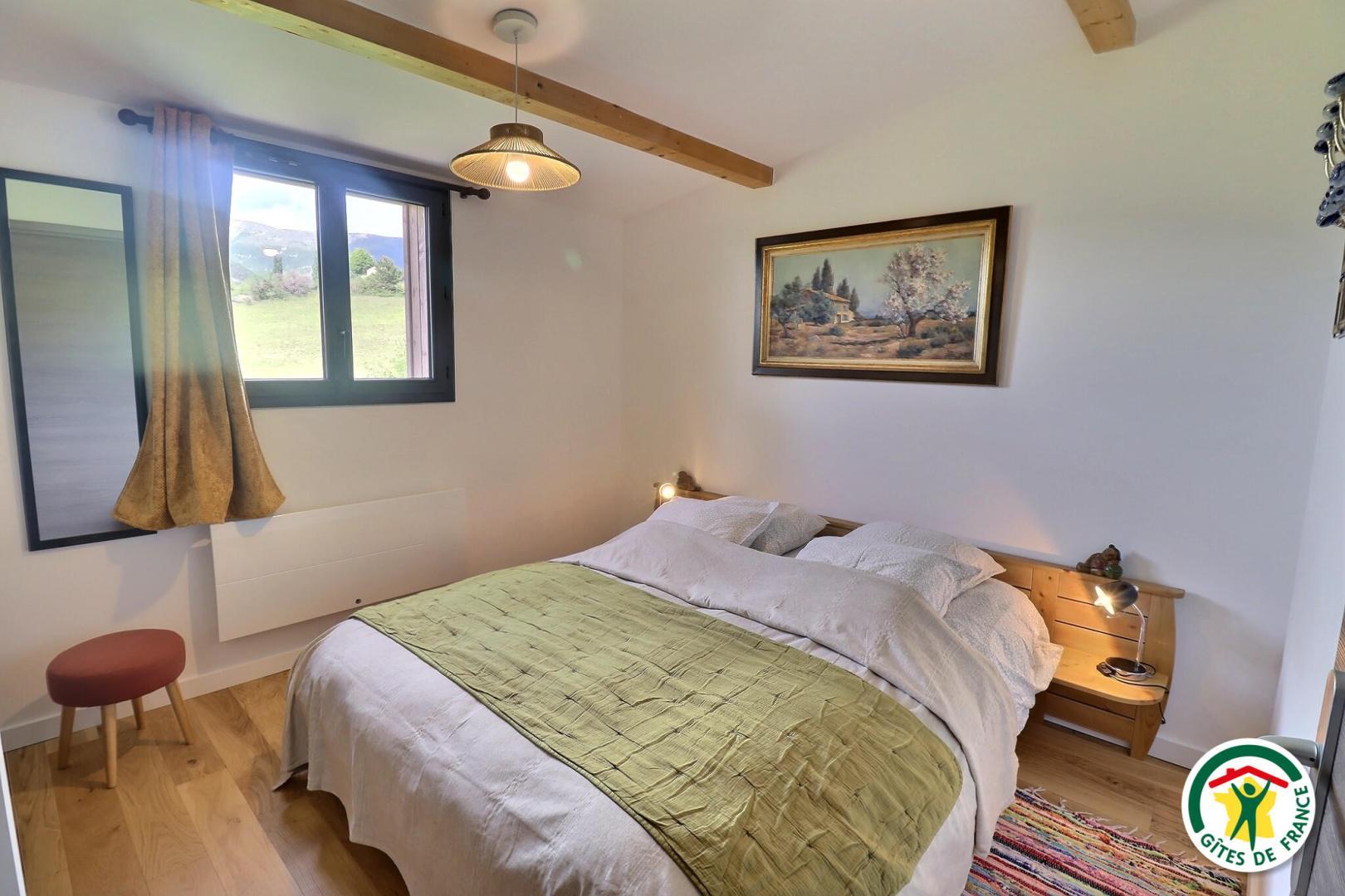 La chambre : lit 160x200cm fenêtre avec moustiquaire et rideaux