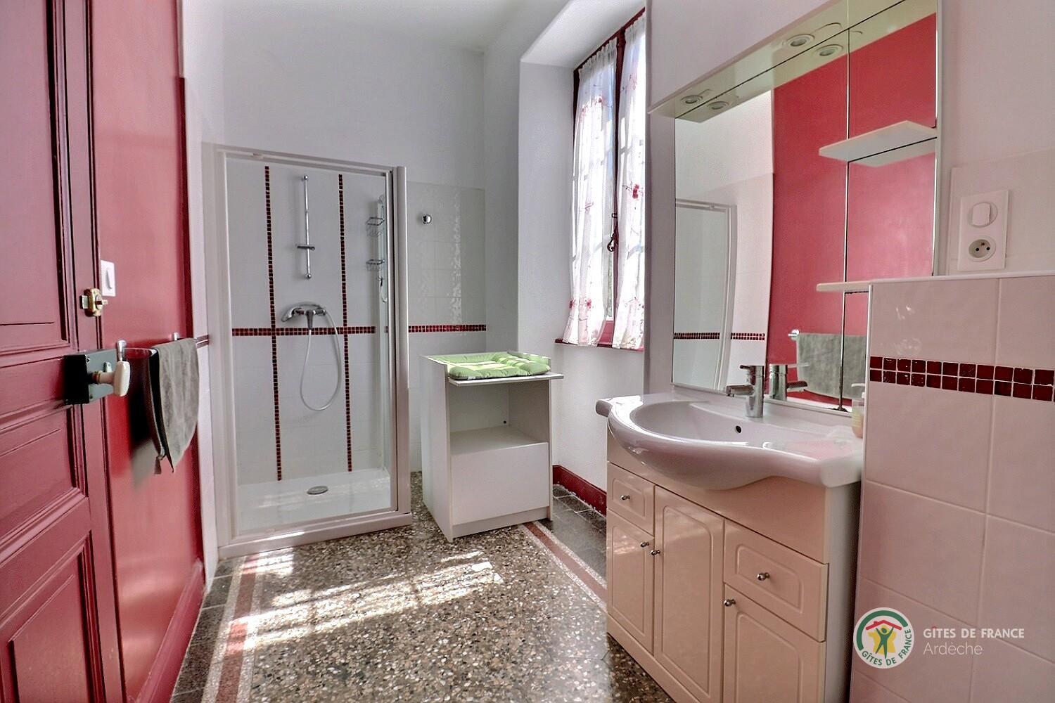 Salle d'eau du second niveau avec douche, vasque, toilette et table à langer