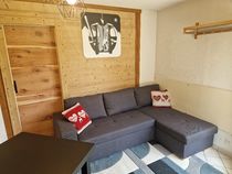 Salon avec canapé, coussins, tapis, tableau au mur