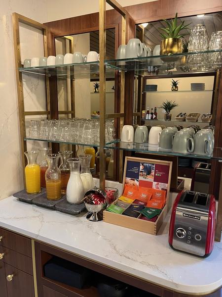 Une étagère du petit-déjeuner avec tasses,  jus, lait, thés, grille-pain.