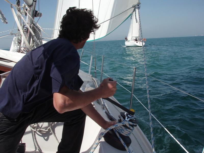 un skipper vue de dos en train de faire une manoeuvre.
