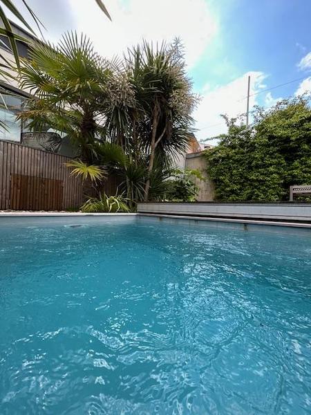 Piscine découverte, dans le fond des palmiers.