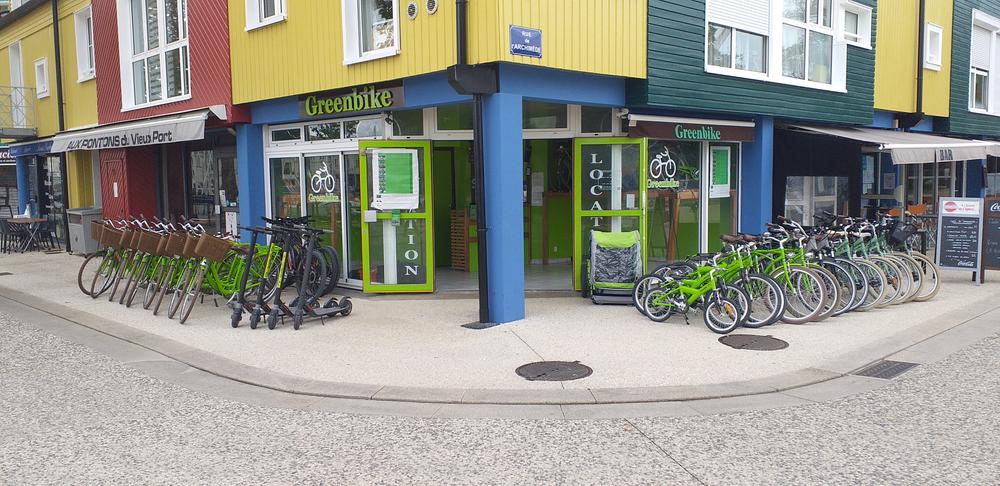 Une trentaine de vélos et des trotinnettes électriques de chaque côté de l'entrée de la boutique.