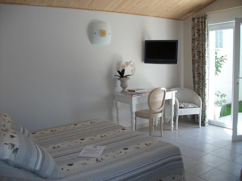 Une chambre avec un lit double, une télévision et un bureau.