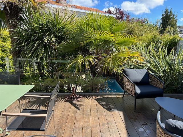 Terrasse avec salon de jardin, fauteuils.