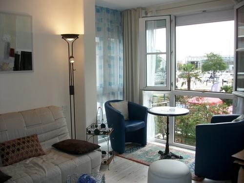 Canapé, fauteuil et table, fenêtre ouverte.