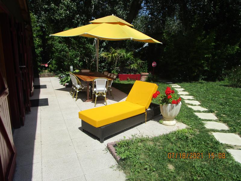 Terrasse du chalet avec transats, table et chaises de jardin