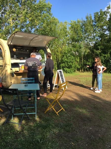 Un foodtruck avec des clients devant.