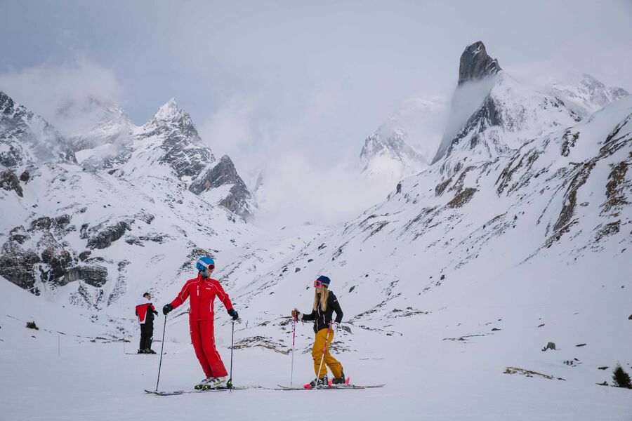 Skier in a private lesson at the ski area with a view of Aguille de la Vanoise Spire