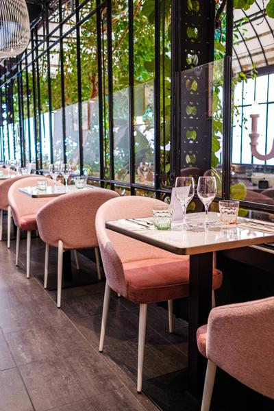 Des tables de deux dressées au niveau du balcon bar, avec vue sur la salle du dessous.