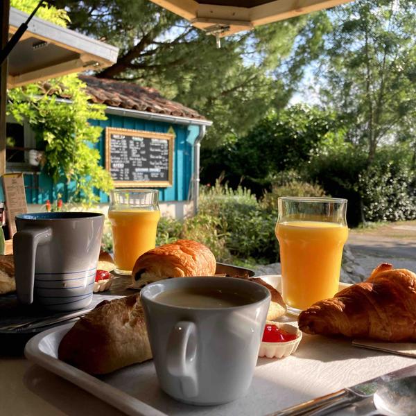 un petit-déjeuner servi au bar, avec viennoiseries, jus d'orange, boissobns chaudes.