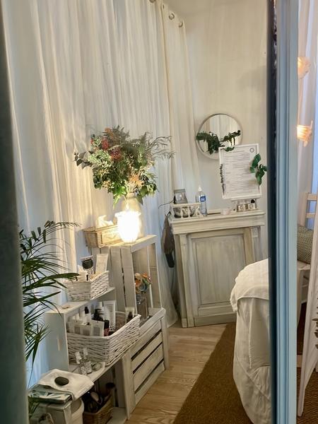 Un espace tamisé avec un bureau d'accueil, des produits cosmétiques et de la décoration zen.