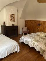 Chambre à coucher lumineuse avec deux lits doubles, ameublement bois