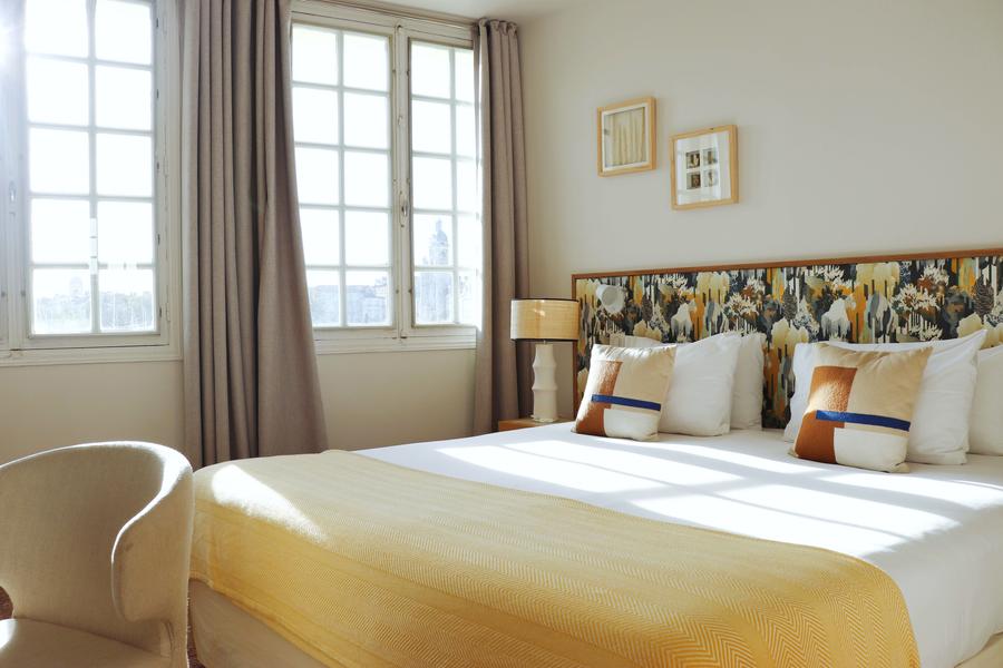 Une chambre avec lit double et couvre-lit jaune.