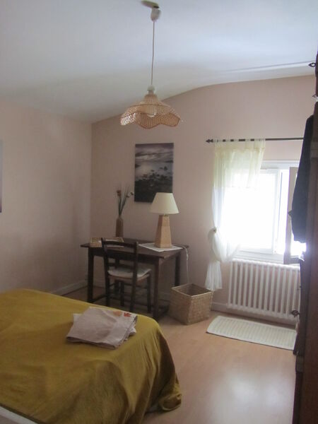 Chambre avec bureau, fenêtre et décorations.