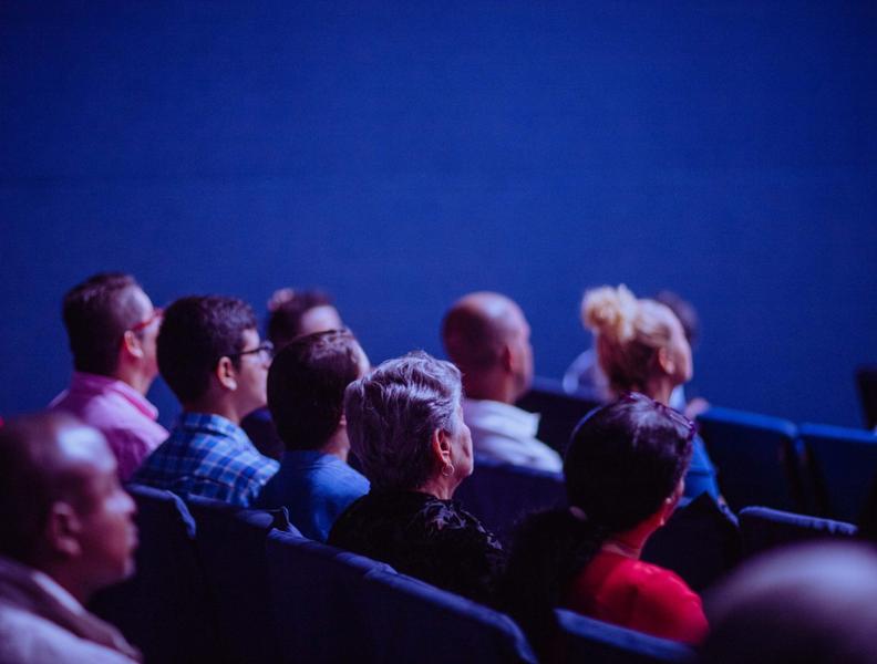 Plusieurs personnes assises dans une salle de spectacle