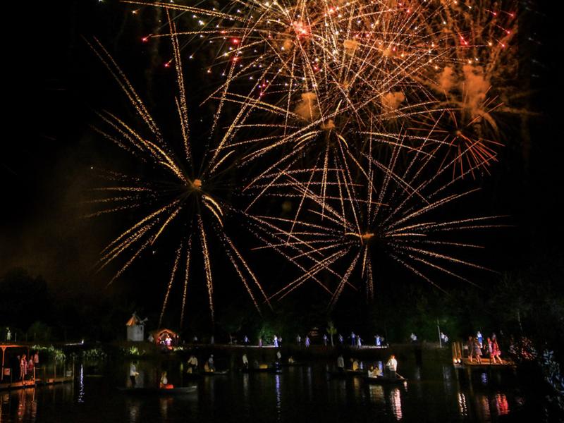 Feu dartifices et acteurs navigant dans des barques