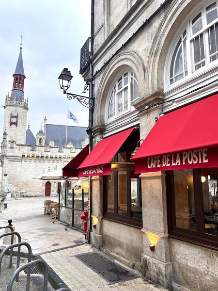 la facade extérieure latériale du restaurant, avec les stores rouges déployées.