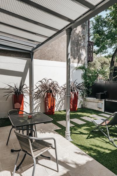 terrasse en dalle sous pergola, faux gazon, table et chaises, portail.