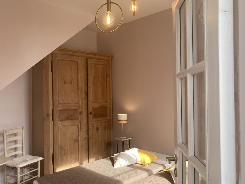 Une chambre avec un lit, une armoire.