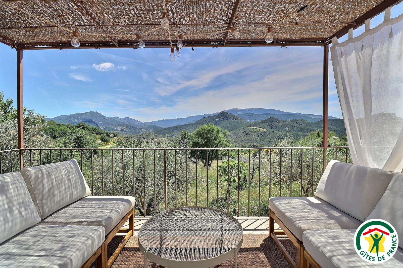Coin détente avec canapés, pergola pour protéger du soleil, vue exceptionnelle sur les montagnes et le mont Ventoux