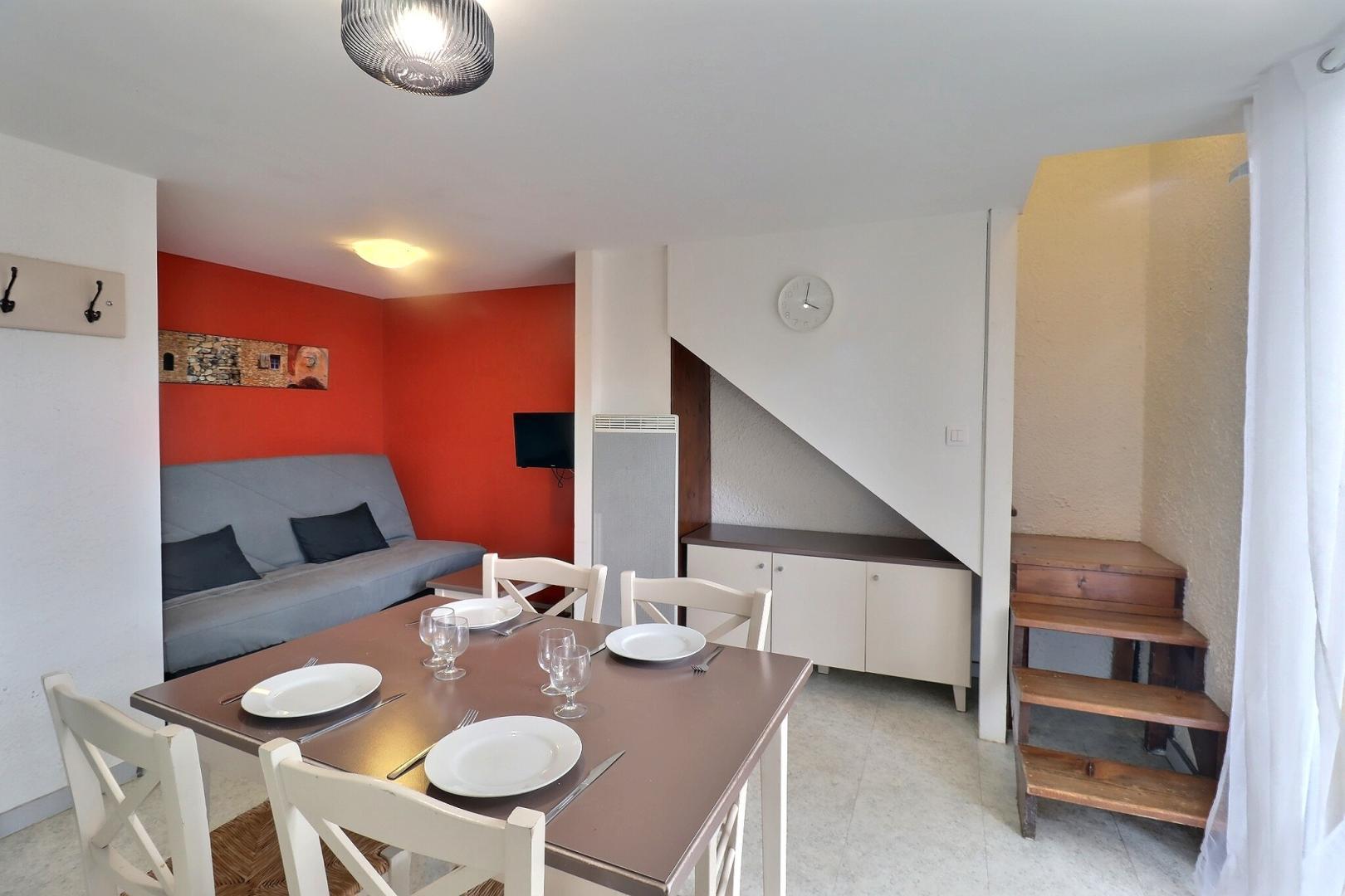 Pièce à vivre avec espace repas et coin salon TV (canapé convertible clic-clac 1x140)
