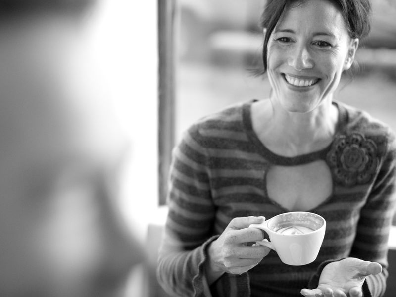 femme souriante qui boit un café