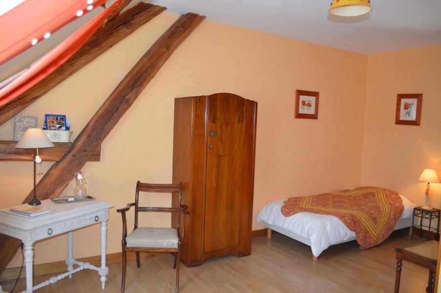 Autre vue, un lit supplémentaire permet d?accueillir une personne; l'armoire anglaise, petit bureau, peint en blanc, et son fauteuil anglais. Des poutres laissées apparentes donnent du charme à cette chambre abricot 