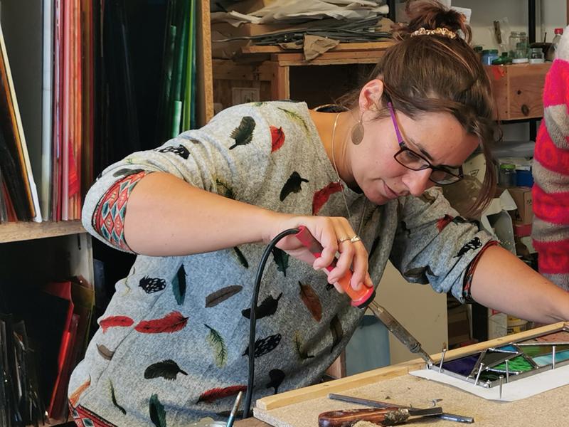 Artisan qui soude deux carrés de verre