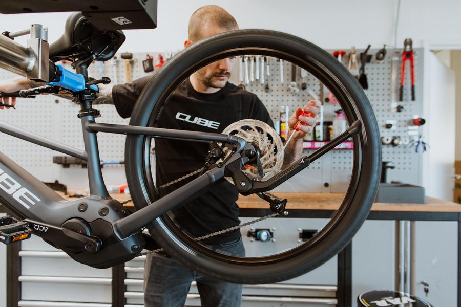 Un salarié réparant une roue arrière de vélo.