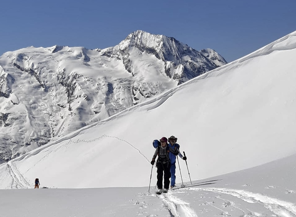 Groupe de skieurs rando évoluant dans un décor hivernal en hors piste, accompagné par un moniteur Snocool