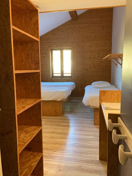 lits simples et rangement dans chambre privée pour 3 personnes