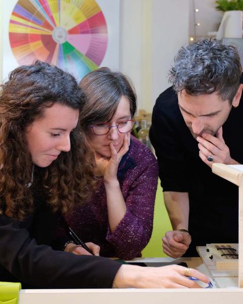 Deux femmes et un homme étudiant les indices de l'escape cook.
