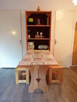 Salon de studio lumineux avec table à manger pliante ouverte, ameublement bois