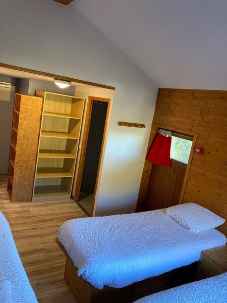 lits simples et rangement dans chambre privée pour 3 personnes
